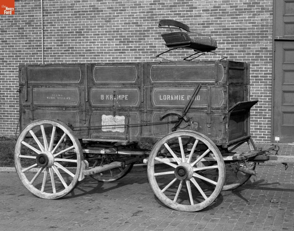 Fish Brothers Farm Wagon, 1895-1902 Boxy wooden wagon with text on side and driver's seat on top