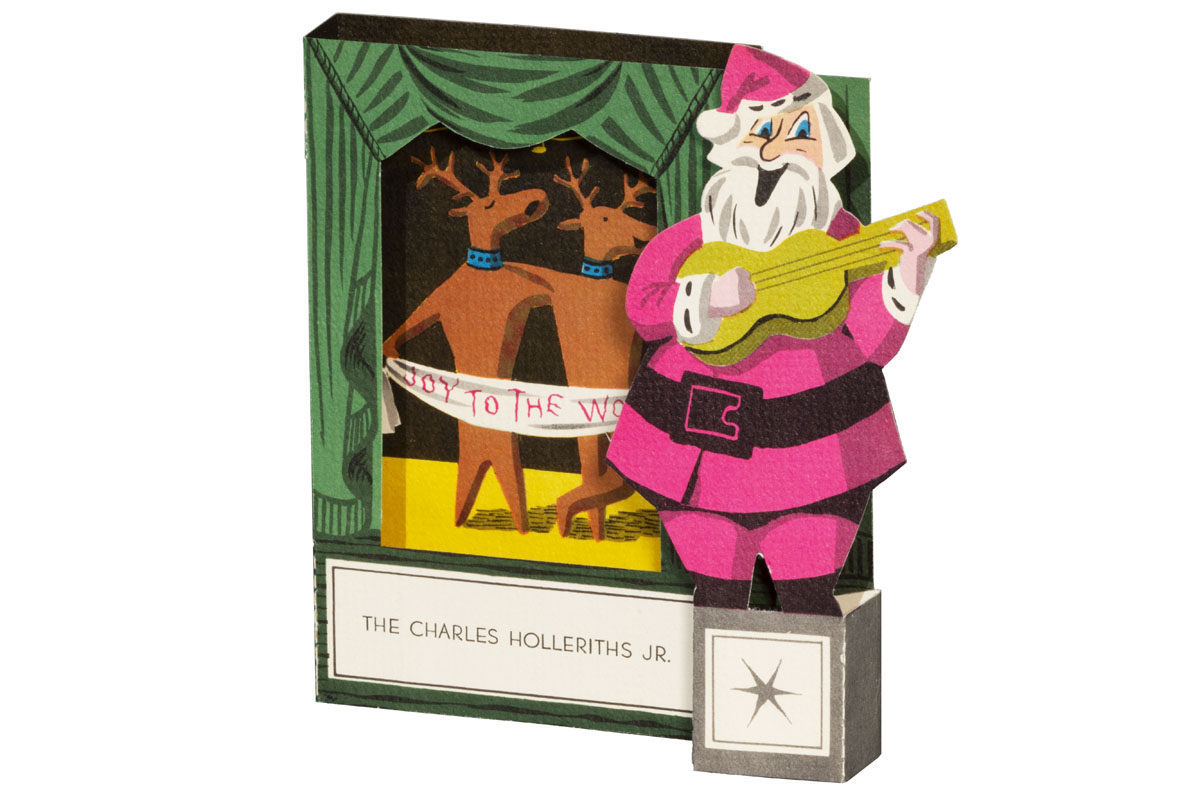 Pop-up greeting card featuring Santa playing a guitar and two reindeer on a stage holding a banner; also contains text
