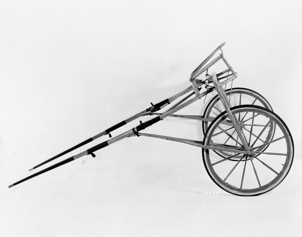Minimal conveyance with two wheels, rudimentary seat, and two bars for attaching to a horse