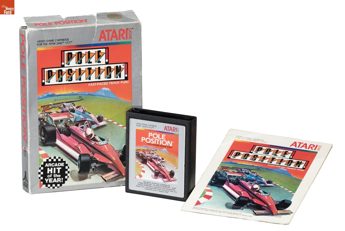Box, cartridge, and booklet for "Pole Position" video game, with text and image of race cars on all