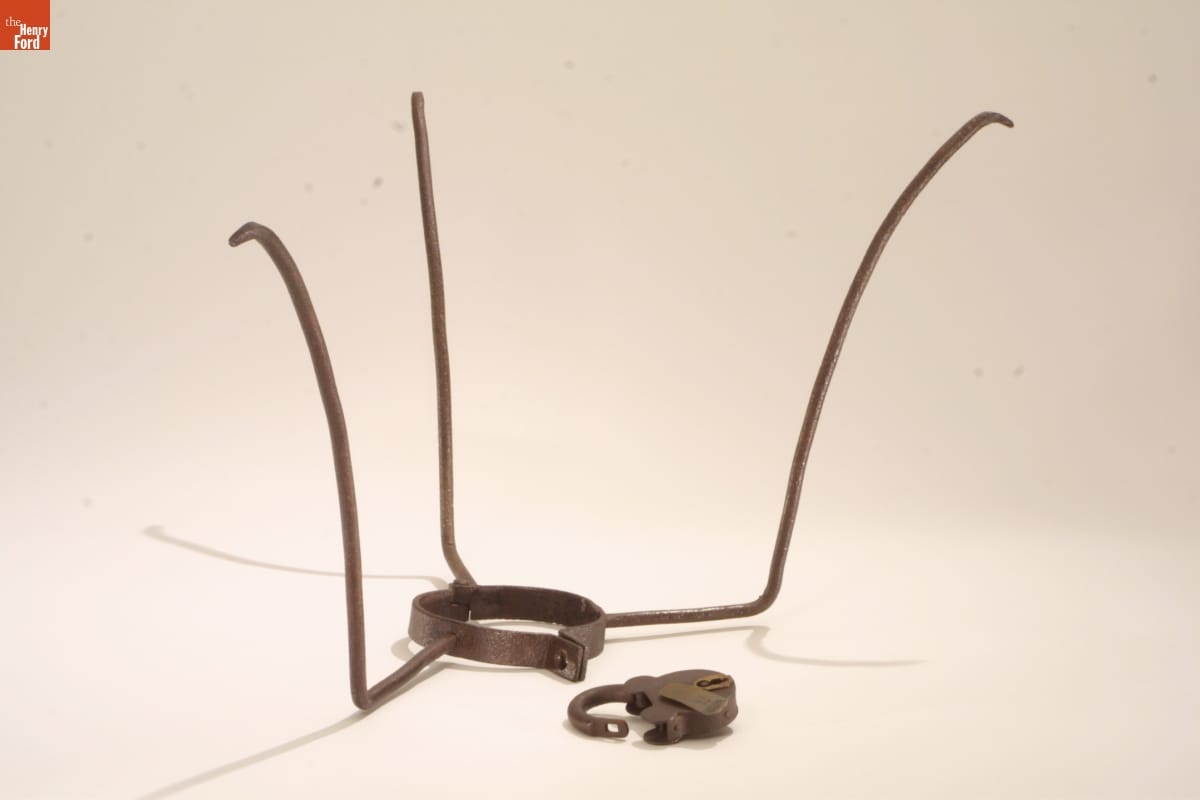 Slave Collar, circa 1860 Metal collar with three tall prongs extending upward and outward; lock nearby