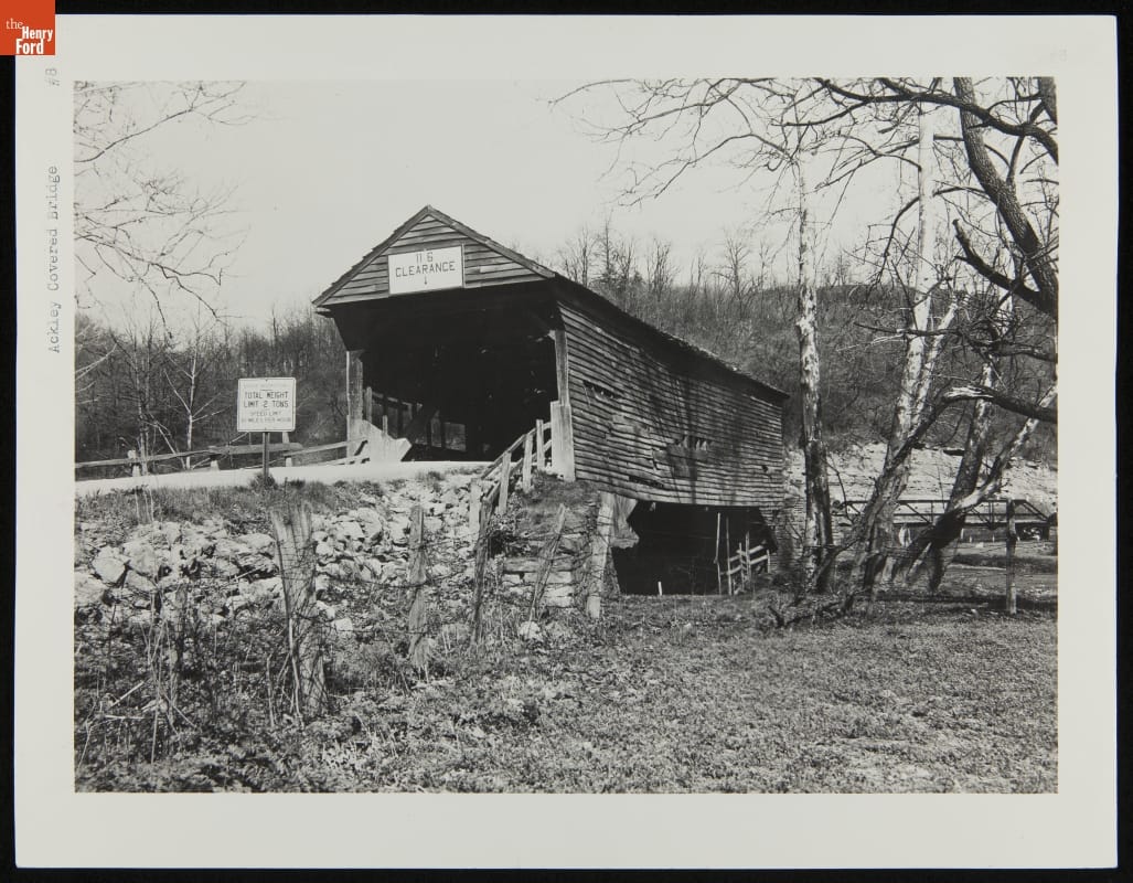 Ackley Covered Bridge at Its Original Site before Relocation to Greenfield Village, 1937 Somewhat ramshackle-looking covered bridge among woods