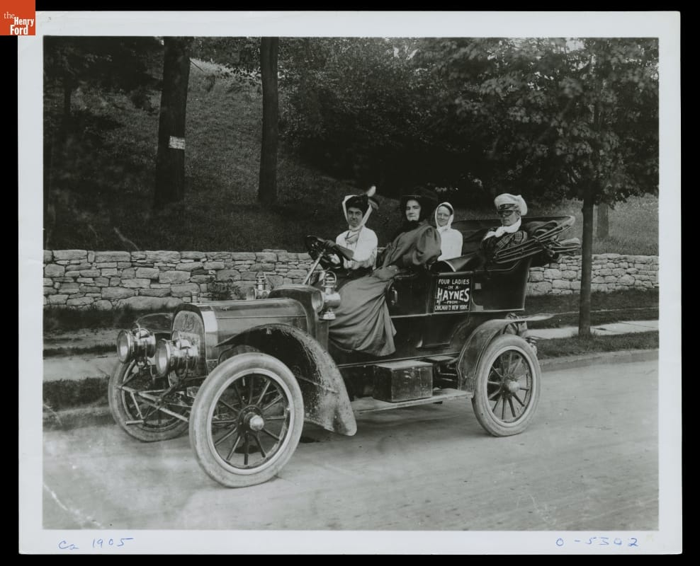 Four women in an open automobile with text on door "Four Ladies in a Haynes from Chicago to New York"