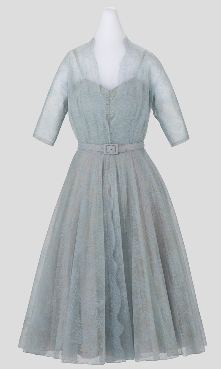 Light bluish-gray lace dress with translucent three-quarters sleeves, full shirt, and sweetheart bodice