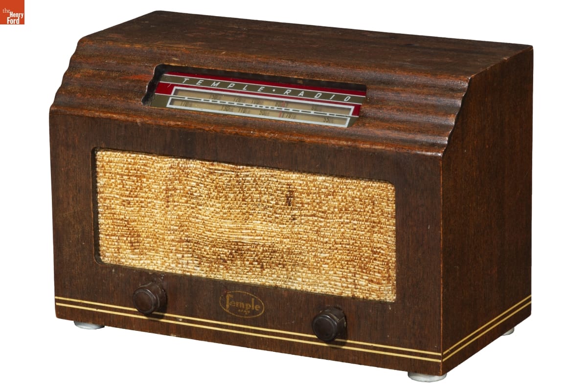 Boxy brown wooden radio with beige fabric or burlap front grille