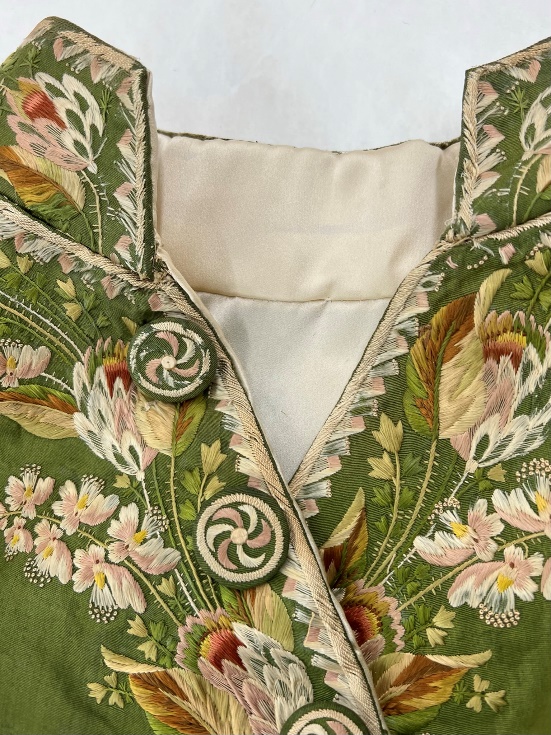 Detail of mandarin-style collar of moss-green jacket with detailed embroidery