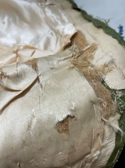 Fabric fraying, stitched together but with gaps revealing stuffing underneath