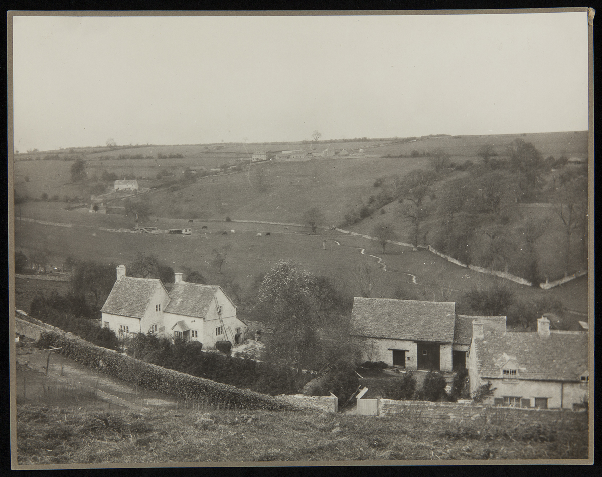 Low stone houses and fences among rolling meadows