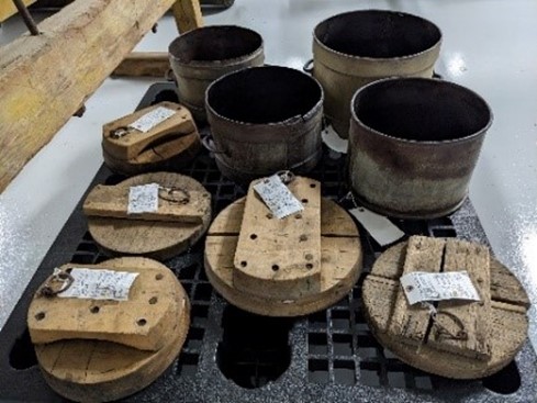 Cheese containers with wooden “followers” to form wheels of cheese