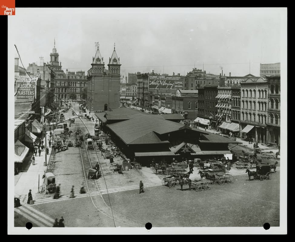 Long, low building in city square, surrounded by roads and other buildings