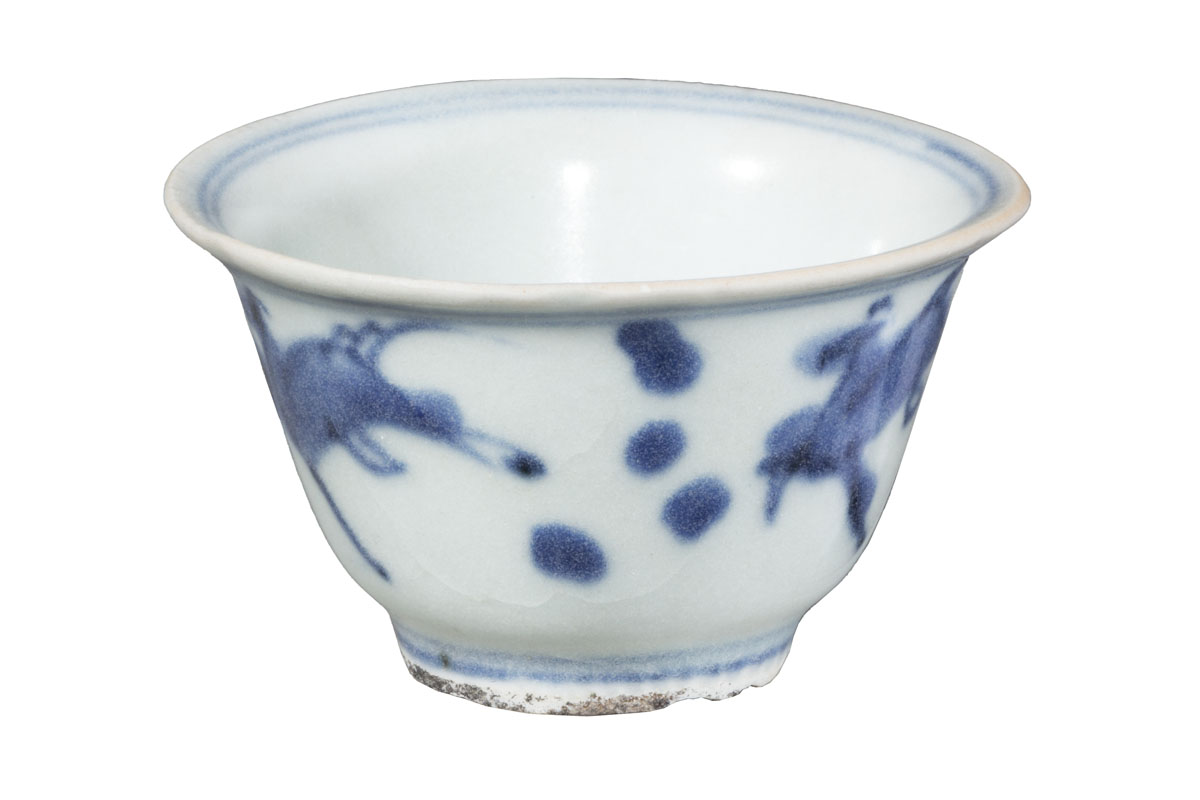 Simple white handleless teacup with blue decorations