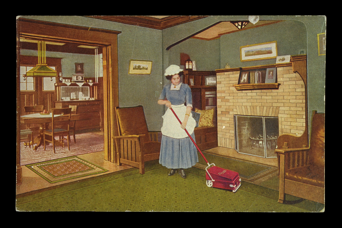 Postcard Advertising the Domestic Vacuum Sweeper Company of Peoria, Illinois, circa 1910 Woman in blue dress with white apron and cap using a sweeper vacuum on a living room carpet