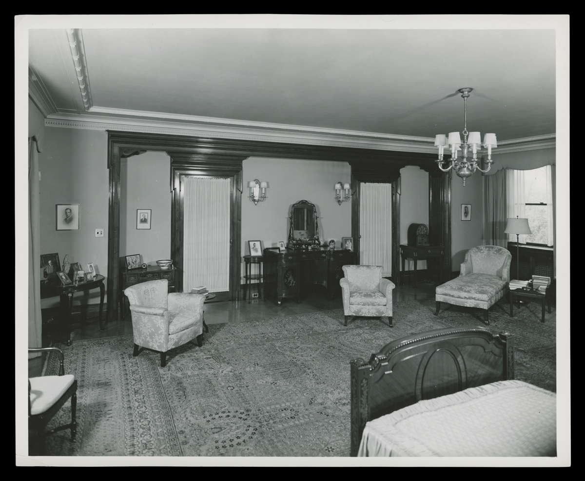 Interior of bedroom with twin bed, chairs, and other furniture