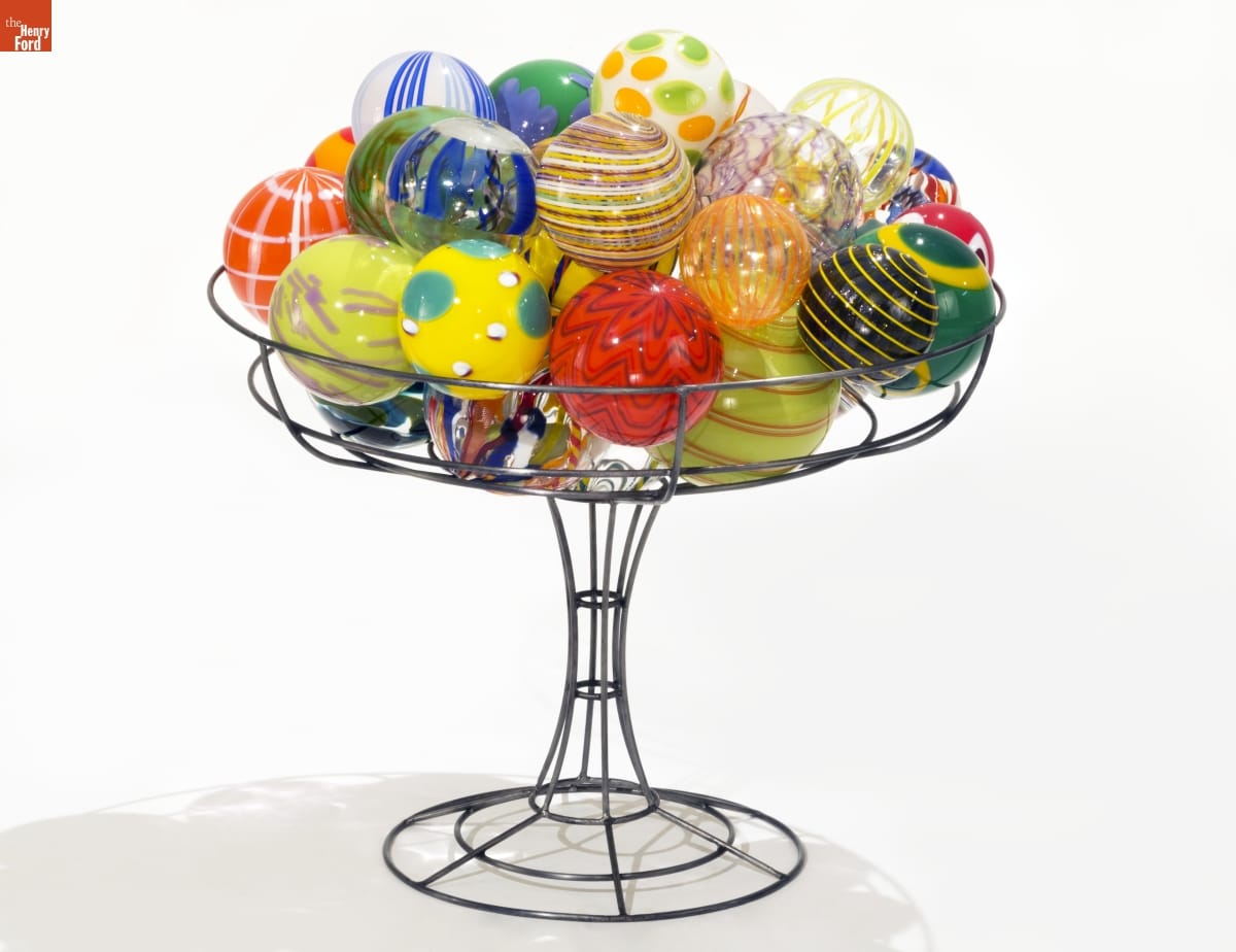Colorful glass balls are stacked in wire "holder" for display