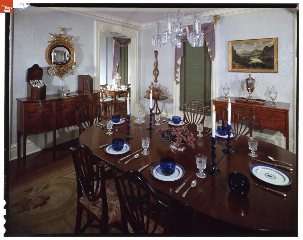 Dining Room in Noah Webster Home in Greenfield Village, 1963 Room containing large wooden dining room table with table settings, two sideboards, and more furnishings
