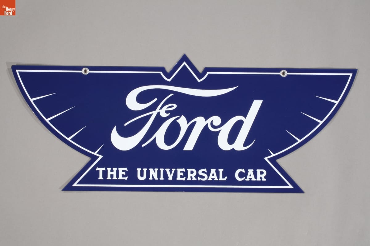 Blue sign in the shape of a stylized eagle with white text "Ford, The Universal Car"