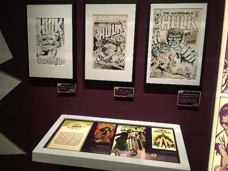 Original artwork for The Incredible Hulk comic books in "Marvel: Universe of Super Heroes" exhibit Three framed drawings with text and images on wall; additional text and images in lighted case below and to right