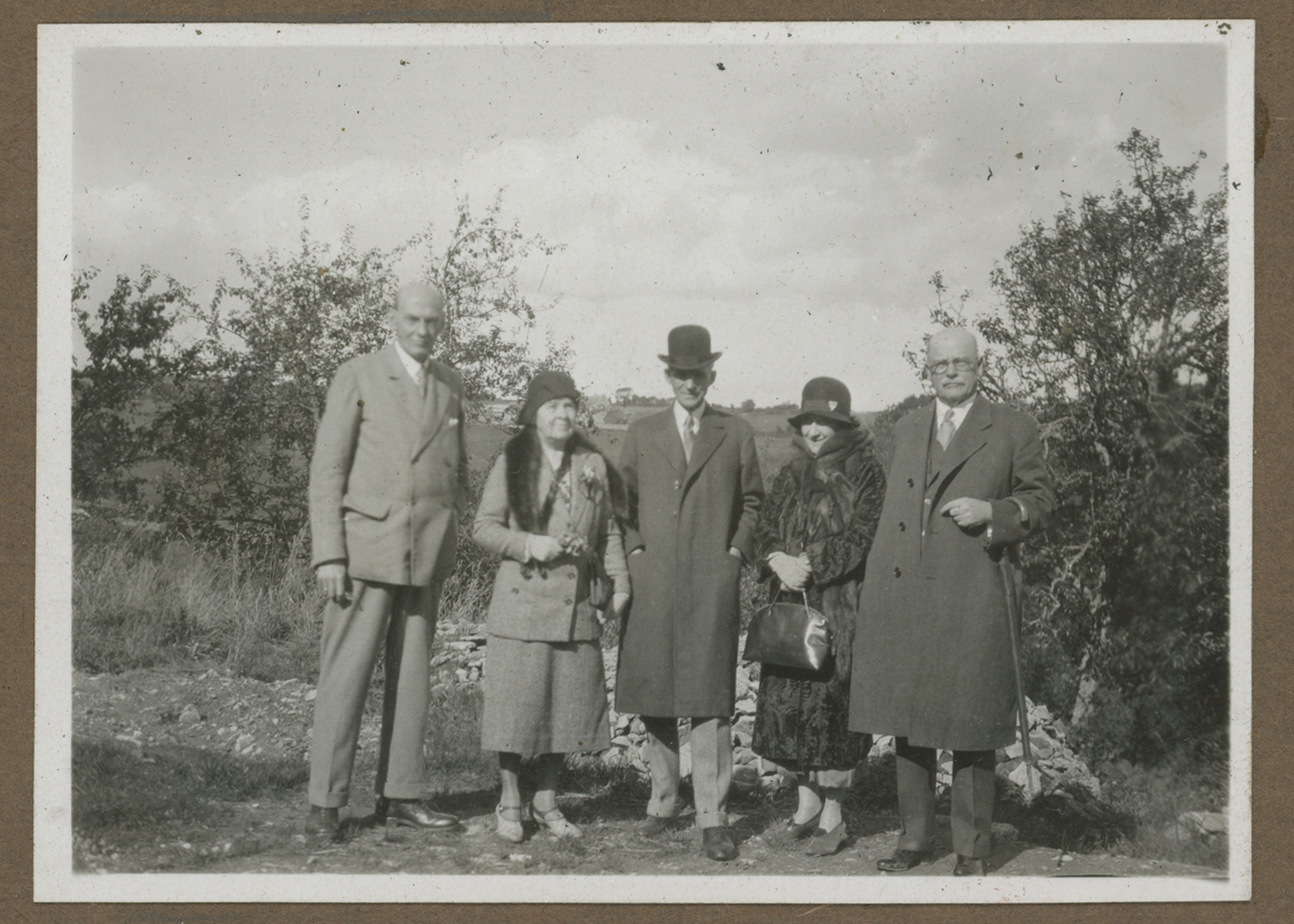 Group of people pose for photo in front of bushes