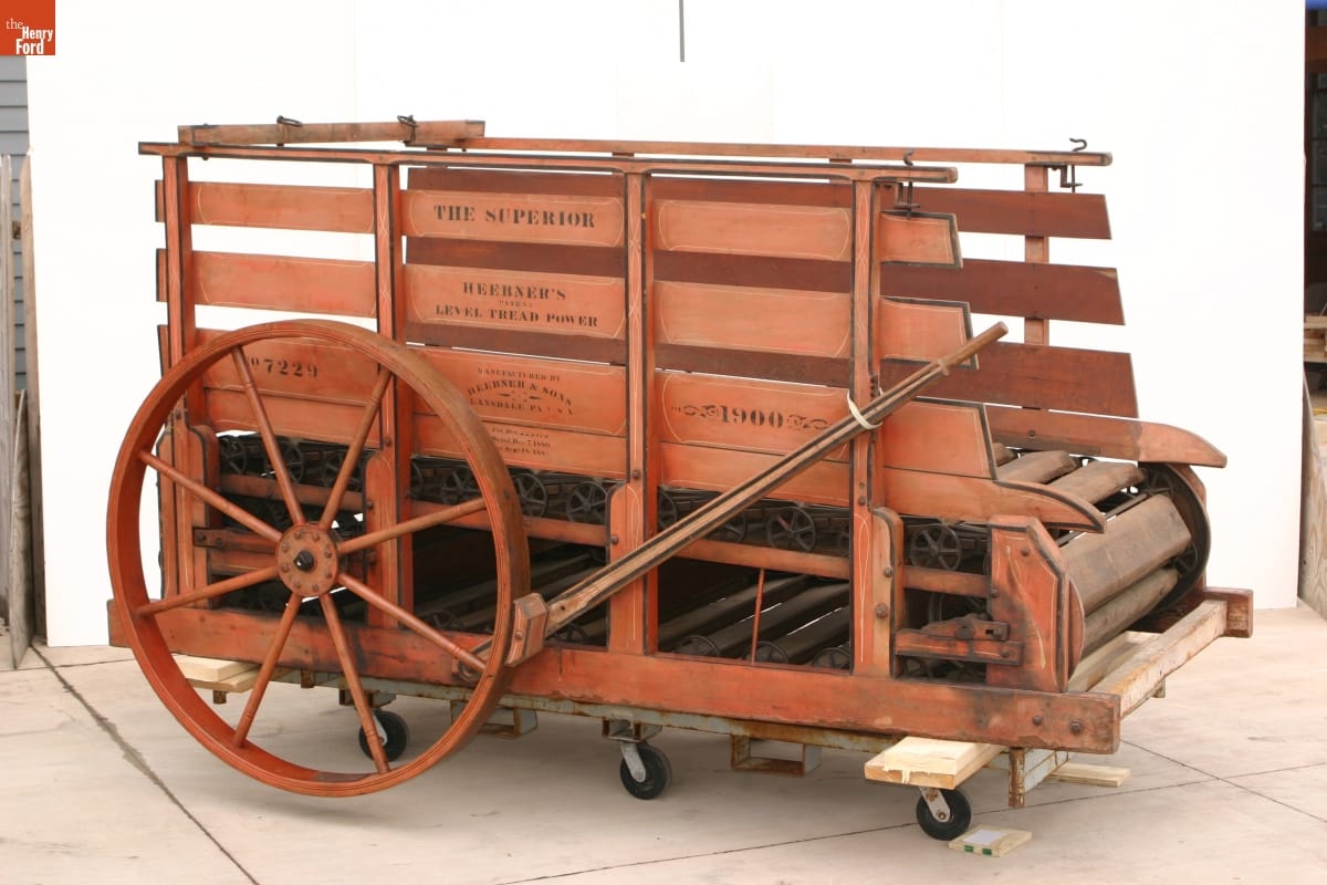 Red treadmill with wooden sides and large wheels in back; also contains text on side