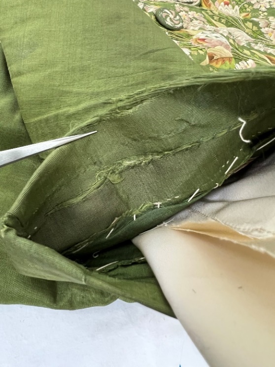 Detail of moss-green fabric with stitching and wear