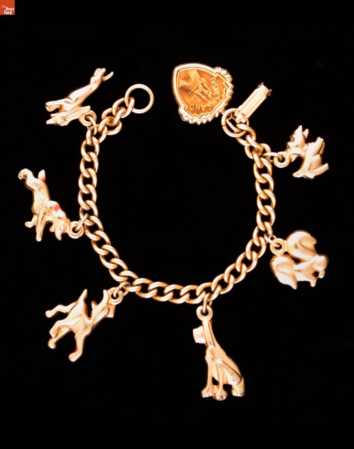 Gold bracelet with six charms of dogs attached