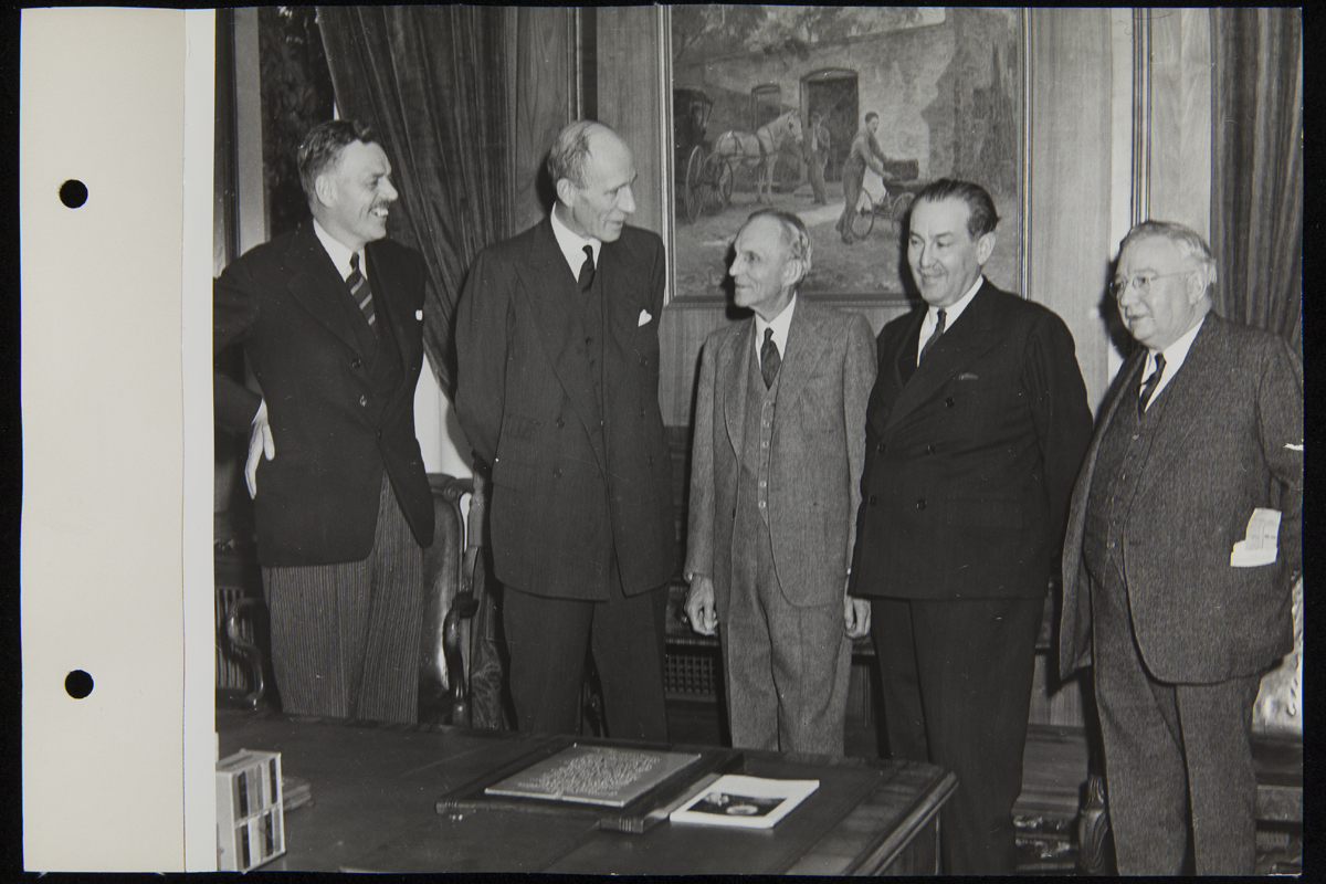 Lord Halifax and Henry Ford with Others in Henry Ford's Office, Engineering Laboratory, November 1941 Five men in suits stand behind a desk in an office