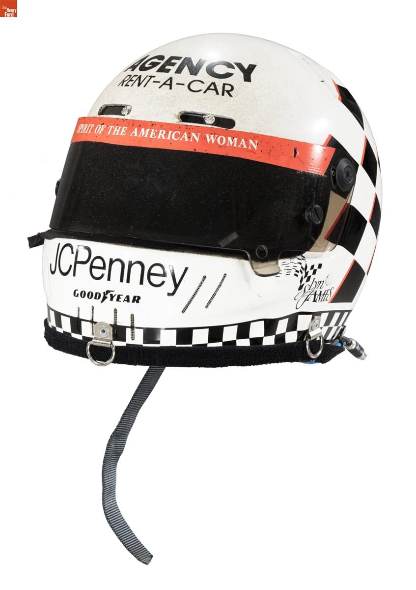 White and black helmet with dark visor and red trim; also contains text