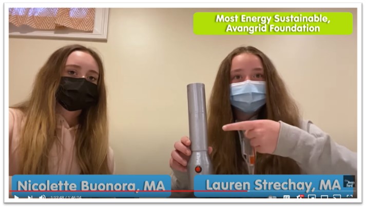 Video screen capture of two girls with long, brown hair wearing masks, one pointing to a flashlight; also contains text