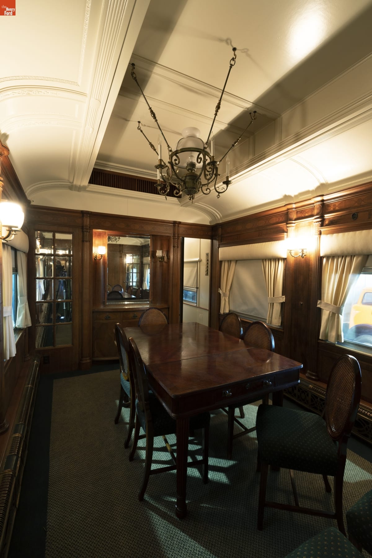 Interior of railcar with wooden walls, table, and chairs