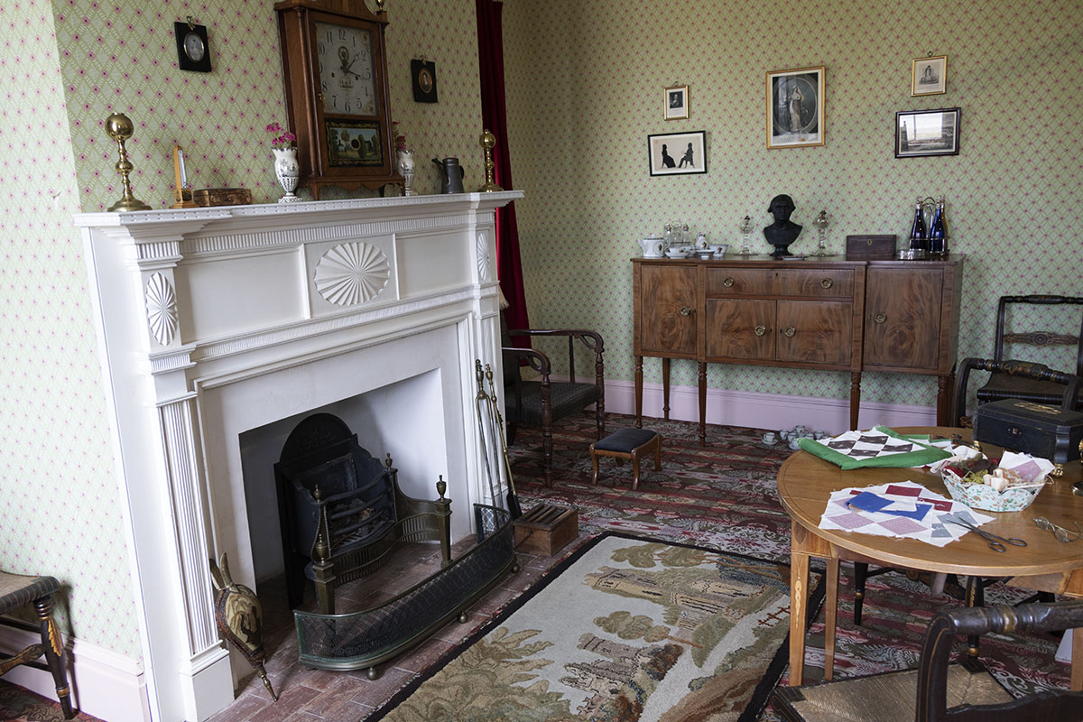 Noah Webster Home / sitting room Room with large fireplace, table and chairs, and other furniture