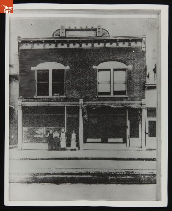 Two-story brick building with sign on top