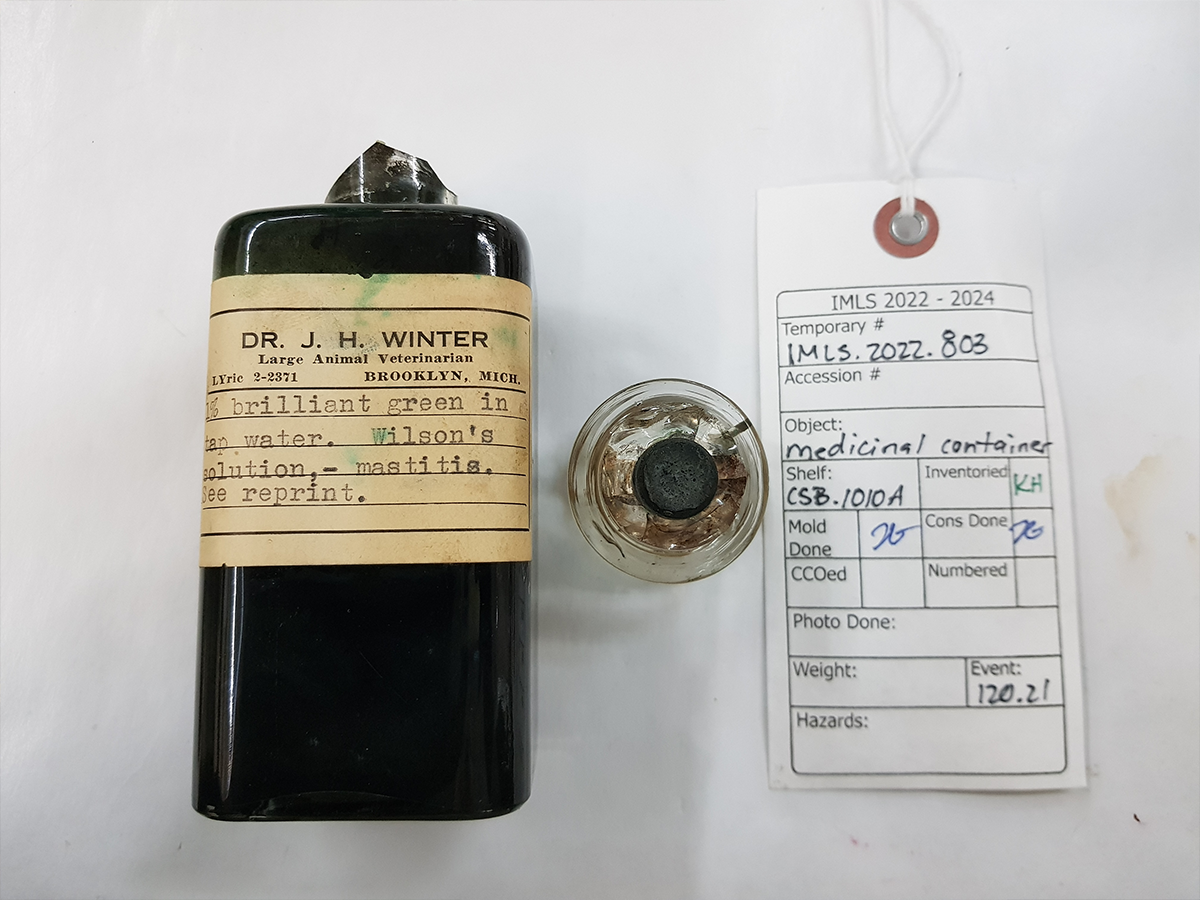 glass medicinal container with a transparent glass lid was filled with a liquid labeled as 