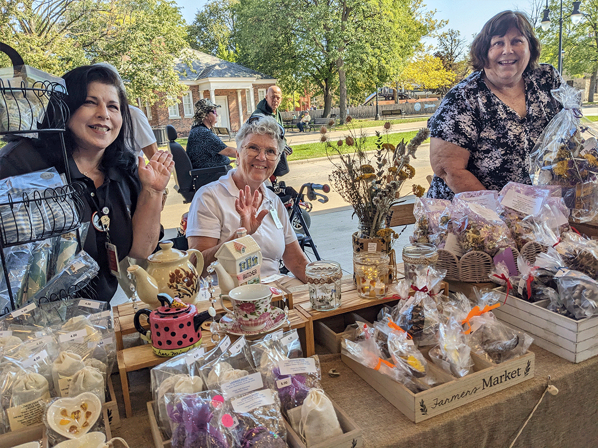 Three women selling goods at an outdoor market