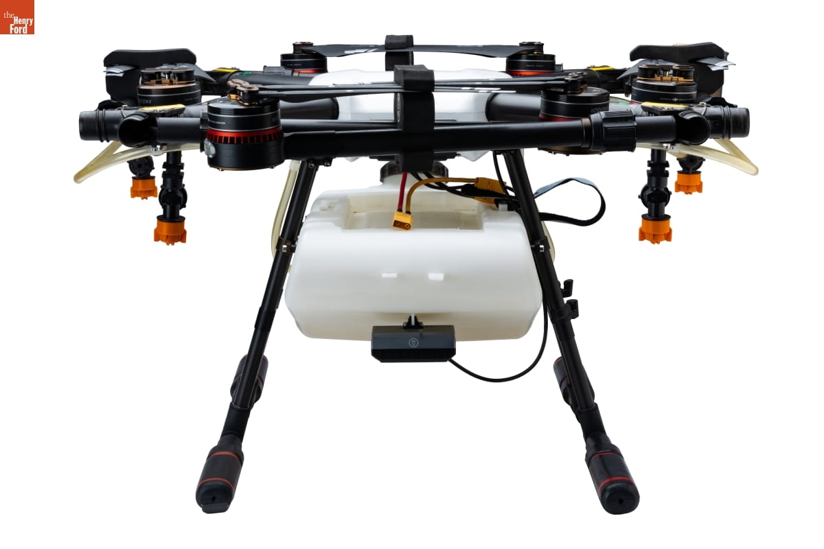 Front view of the Agras MG-1 Drone with propellers folded to show the radar module, spray tank, spray nozzles, and landing gear