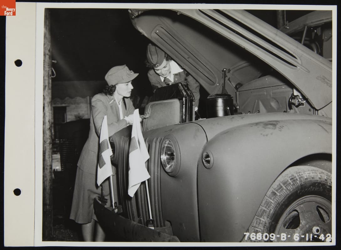 American Red Cross Women's Motor Corps members looking under the hood of a Ford ambulance